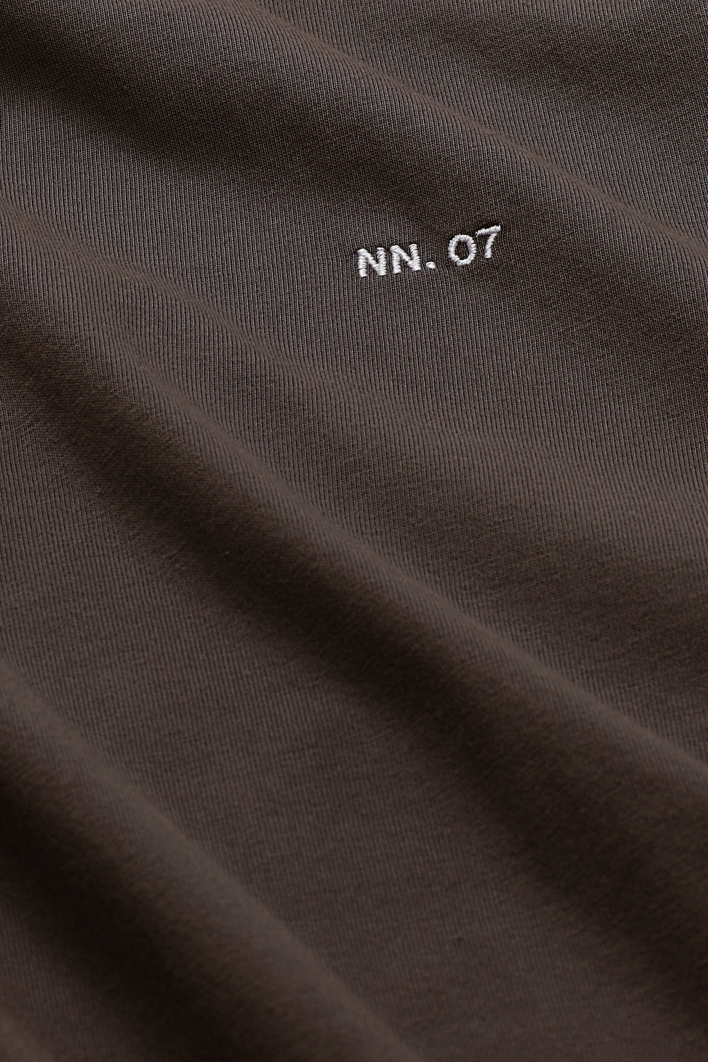 Close-up of dark brown fabric with 'NN.07' logo.